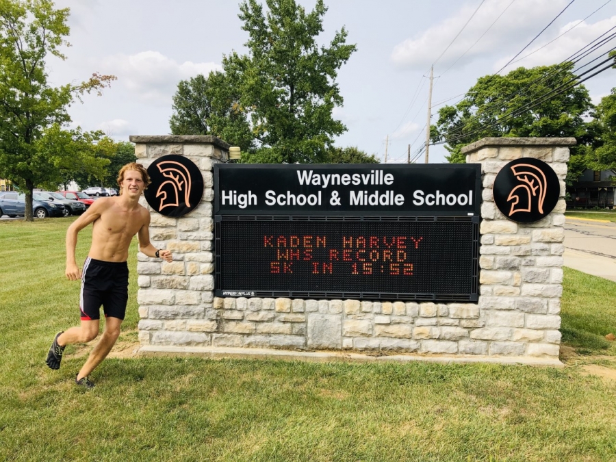 boy posing in front of a stone marquee